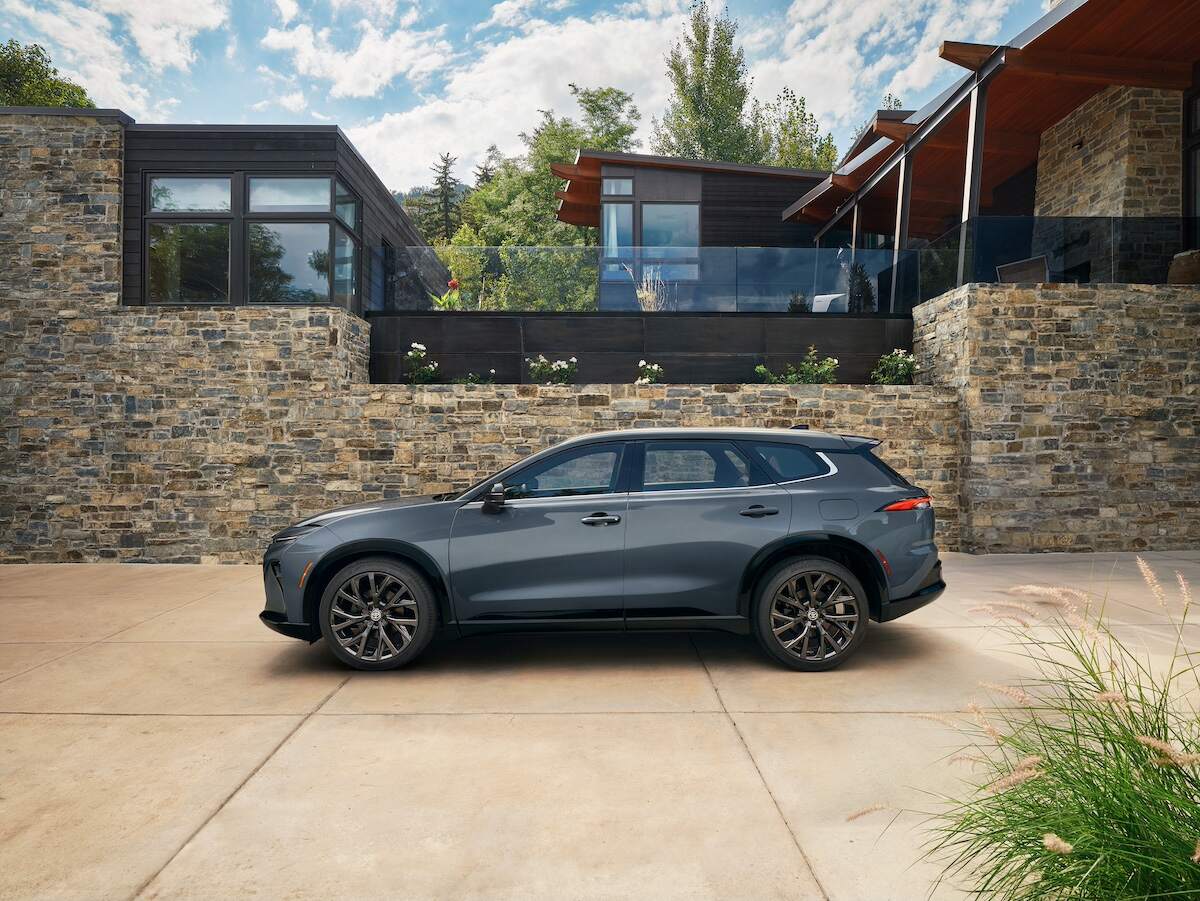 Dark-gray 2025 Toyota Crown Signia parked outside a large modern home