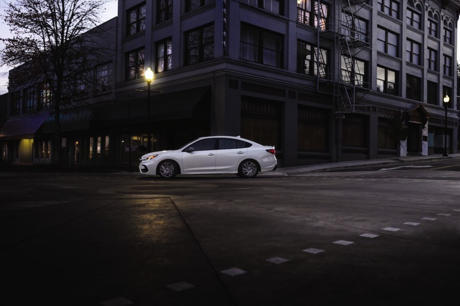 White Subaru Legacy driving in the city. It takes a bit of cash to buy a 2023 Subaru Legacy, but it might be worth the investment.