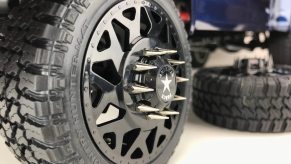 The spiked lug nuts on the aftermarket rims of a lifted pickup truck.