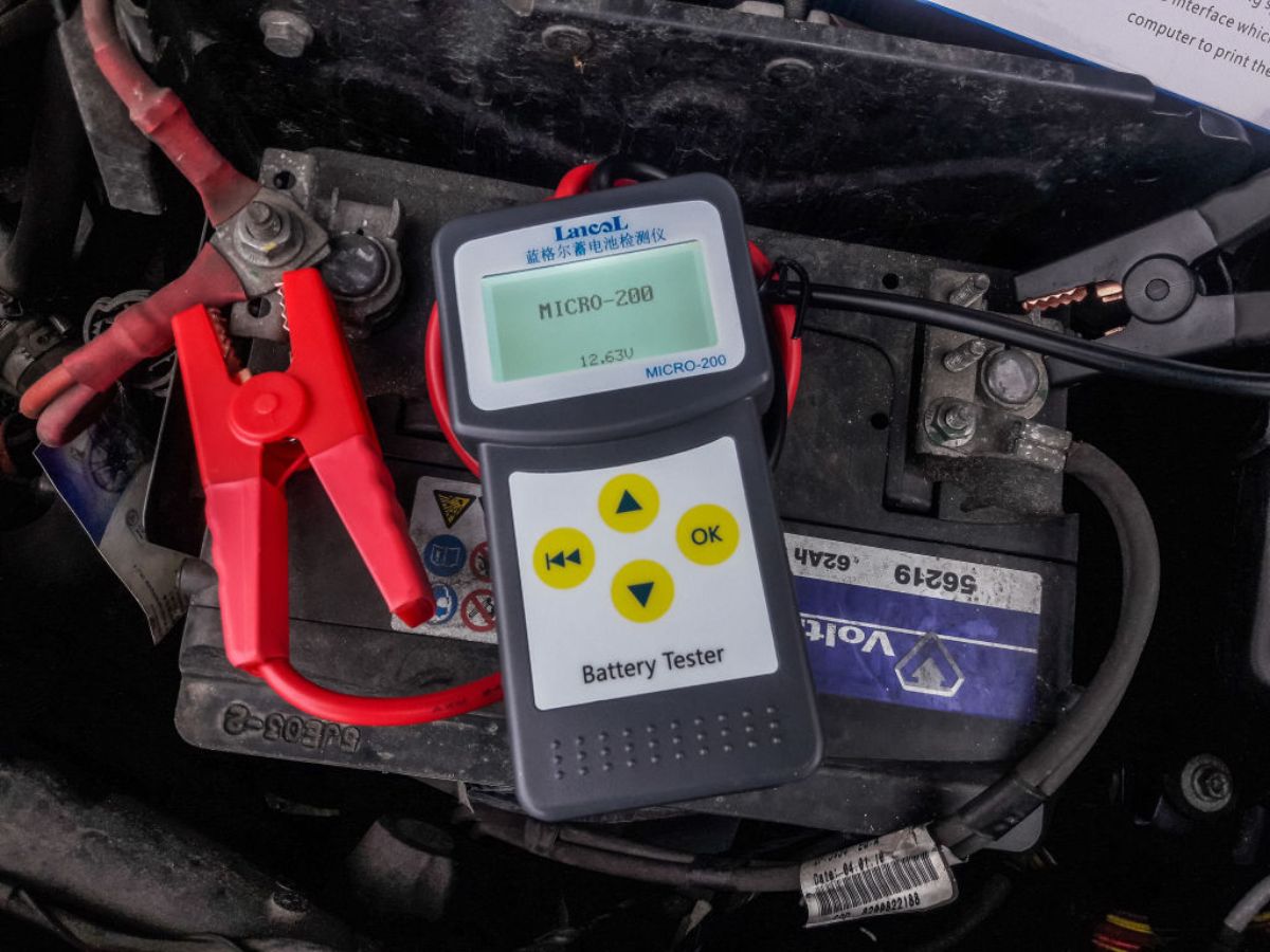 A person getting a reading on a car battery.