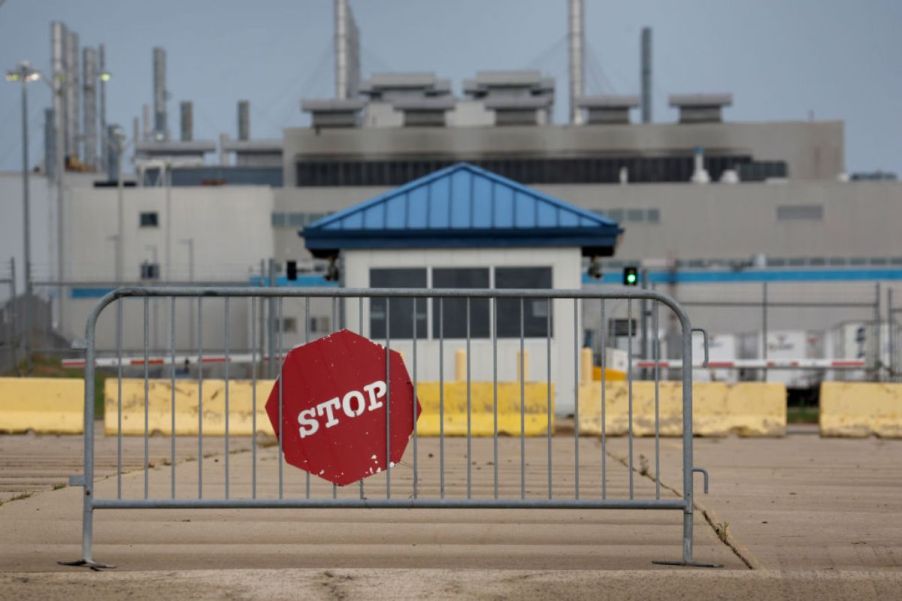 A 'stop' sign outside of a closed car plant.