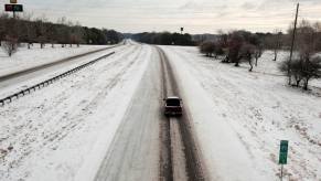 Diesel pickup truck drives down a cold snowy highway during the winter