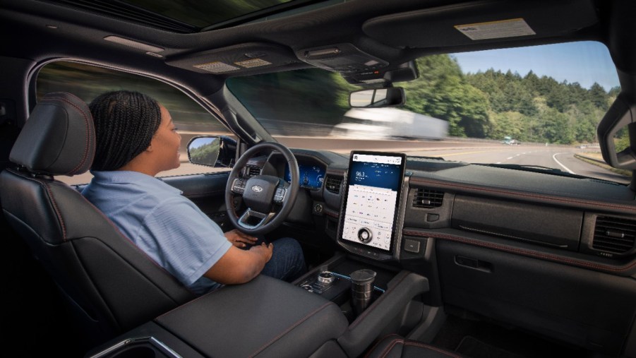 A person driving an SUV using Ford BlueCruise.