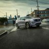 A silver Ford Edge driving on a city street.