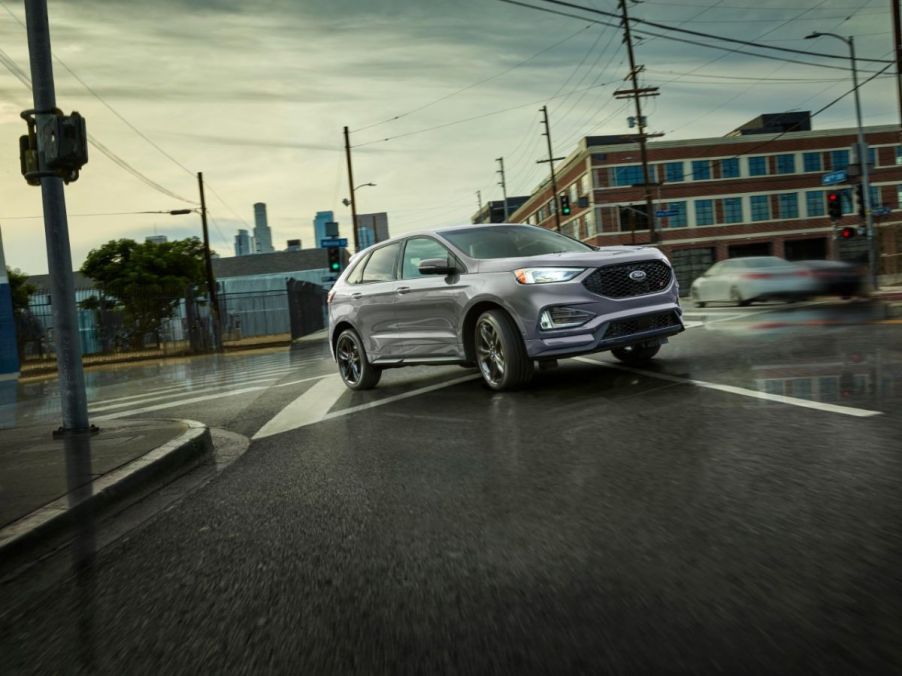 A silver Ford Edge driving on a city street.