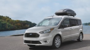 A Ford Transit Connect parked by a lake.