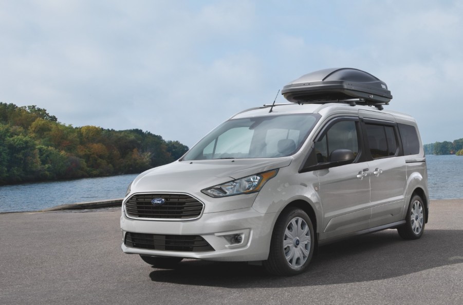 A Ford Transit Connect parked by a lake.