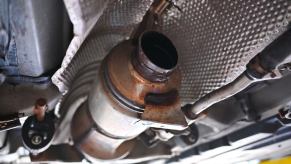 An underside shot shows the aftermath of a catalytic converter theft.