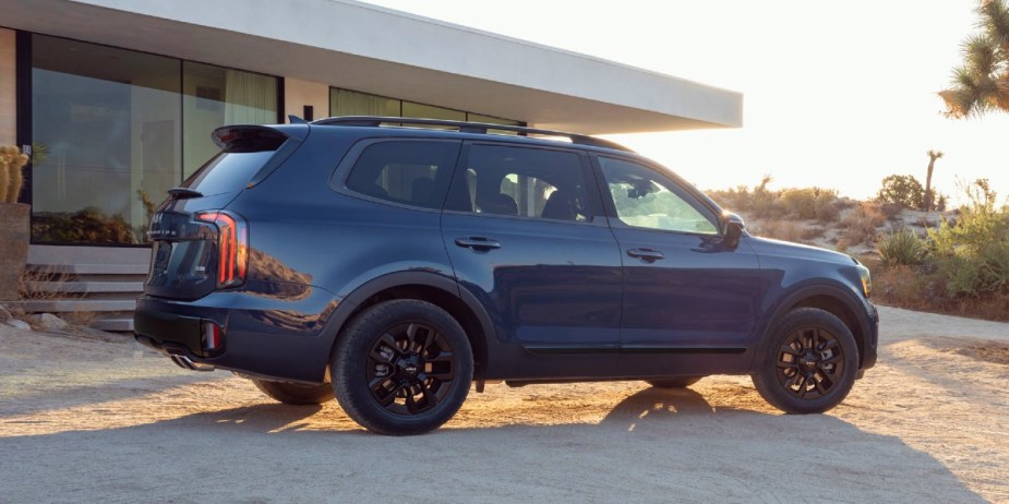 A blue 2024 Kia Telluride midsize three-row SUV is parked (side-view). 