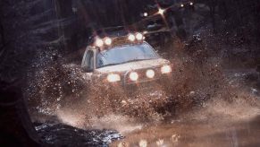 A Land Rover kicks up mud in the most important race in the marque's history, the Camel Trophy.