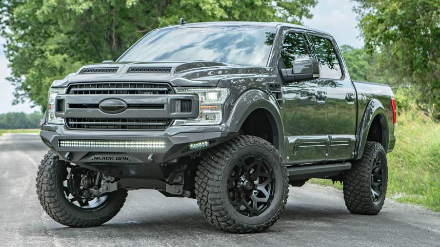 A lifted Ford F-150 driving on the pavement