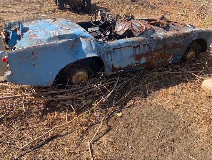 unknown car sitting in a field