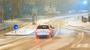 An SUV is driving in the snow.