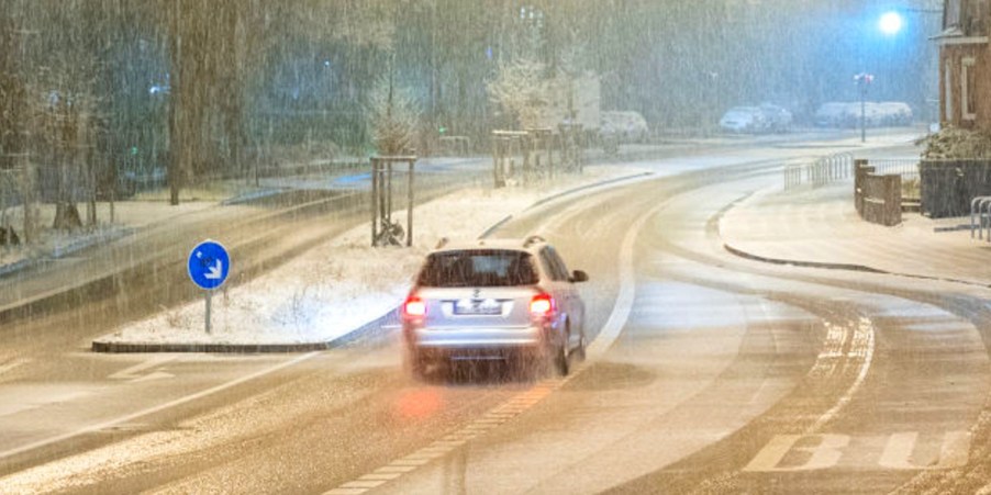 An SUV is driving in the snow.