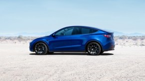 A blue Tesla Model Y small electric SUV is parked.