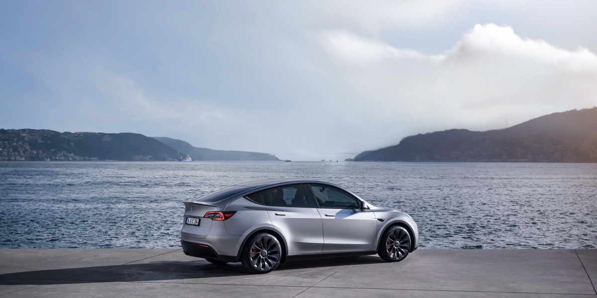 A gray Tesla Model Y small electric SUV is parked.