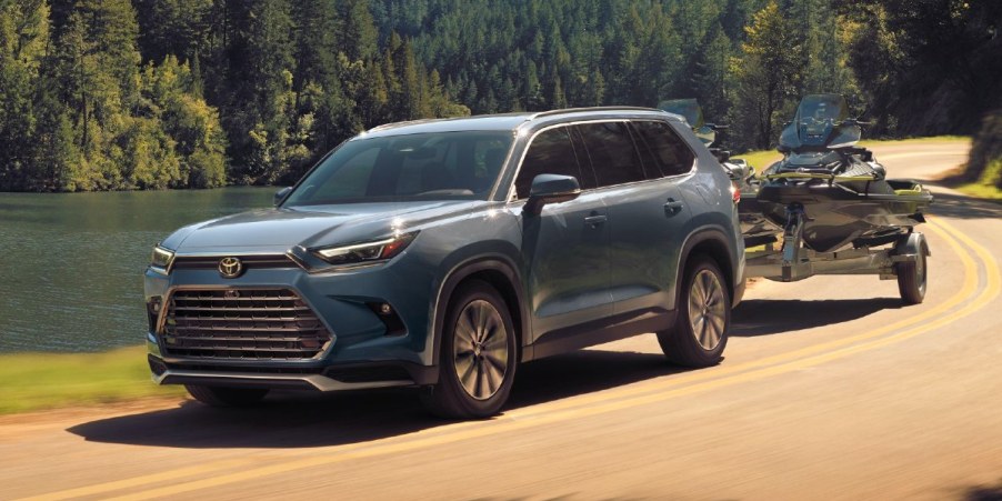 A blue 2024 Toyota Grand Highlander is driving off-road.