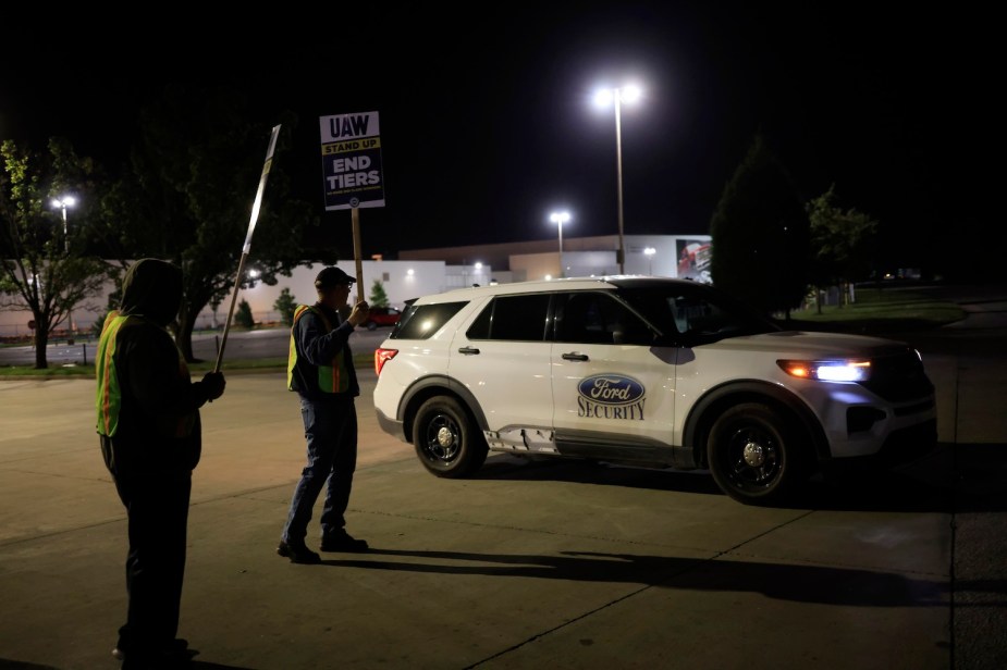 Two Ford UAW factory workers hole strike signs next to a security crossover outside the Louisville, Kentucky plant.