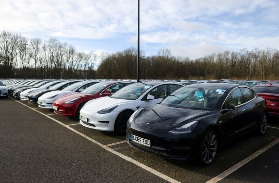 A lot full of used Tesla electric cars await sale with prices lower than last year.