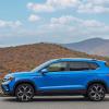 A exterior side profile shot of a 2024 Volkswagen Taos subcompact SUV model parked on a country highway