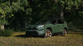 A 2024 Toyota RAV4 Woodland Edition compact SUV model parked at the edge of a forest