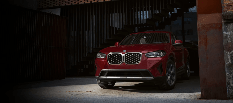 A 2024 BMW X4 xDrive 30i Core sport activity coupe (SAV) model parked in a metal garage