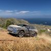 A 2023 Subaru Solterra all-electric compact SUV model covered in dust driving on off-road country trails