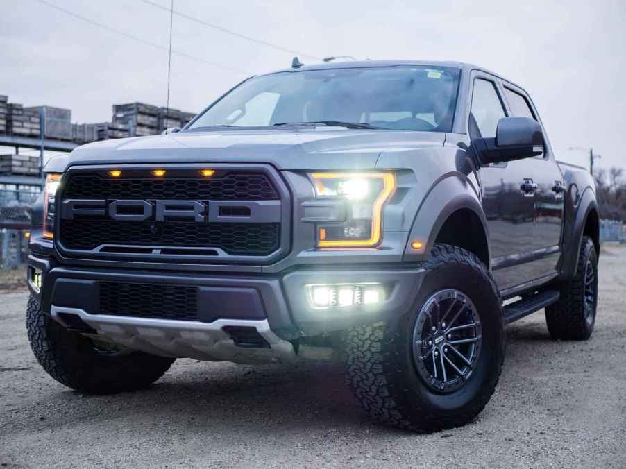 A Ford truck parked at left front angle with lights on