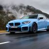 A 2024 BMW M2 subcompact executive sports car model with new performance parts driving on a country highway