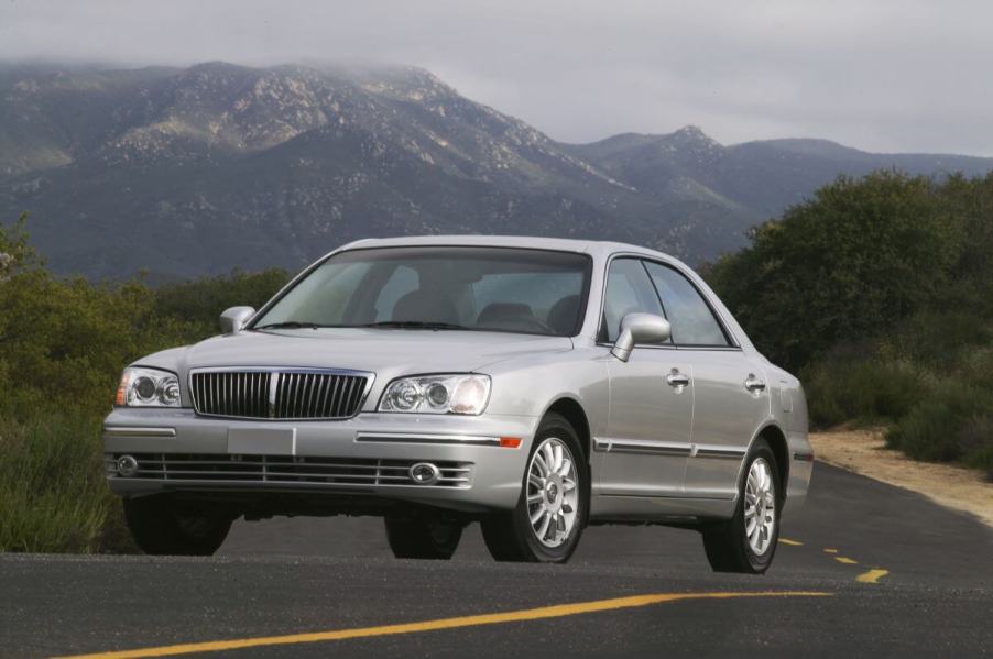 A 2004 Hyundai XG350 luxury sedan model driving in the country with a foggy mountain framed behind it