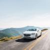 A 2020 Mazda6 midsize sedan model driving down a country highway near forest mountains