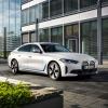 A BMW i4 eDrive40 all-electric luxury sedan model parked on a black tile plaza road