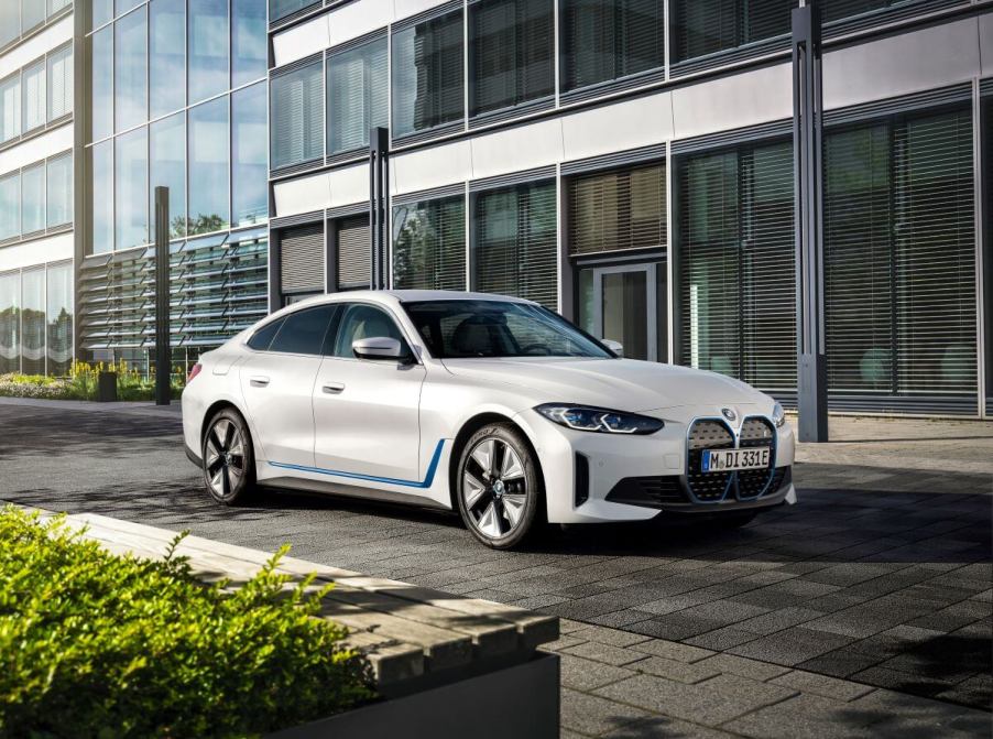 A BMW i4 eDrive40 all-electric luxury sedan model parked on a black tile plaza road