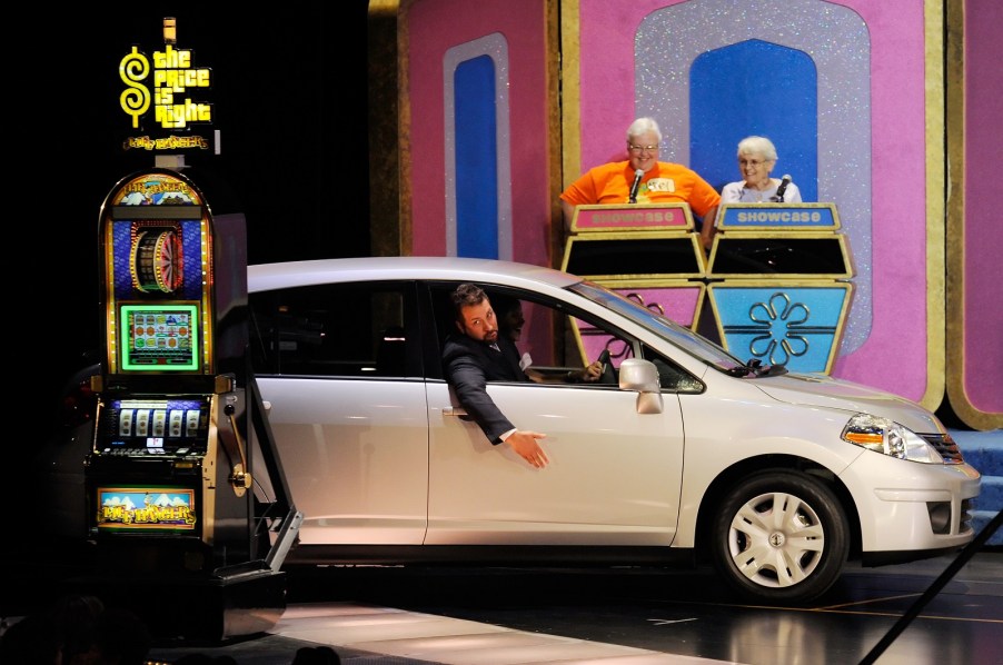 A new silver car being driven onto The Price is Right TV show set during a showcase showdown segment