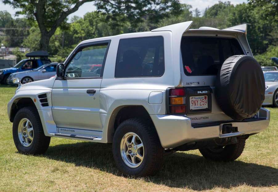 The rear of a silver Mitsubishi SUV parked in a field