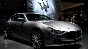 A silver 2016 Maserati Ghibli is shown parked at an auto show in right front angled view