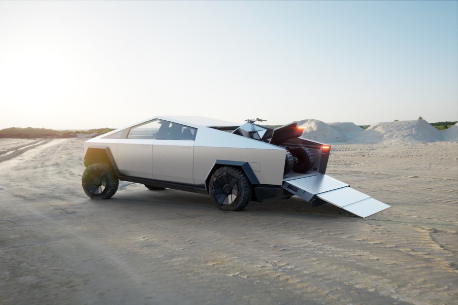 A Tesla Cybertruck carrying a "cyber quad" 4WD with its tailgate and a ramp down.