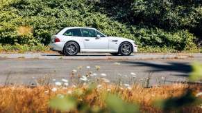 A white BMW M Coupe sits on a back road.