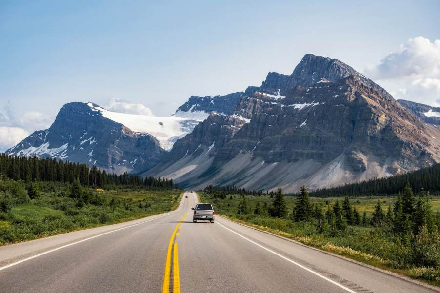 A truck drives toward the Rocky Mountains in Canada