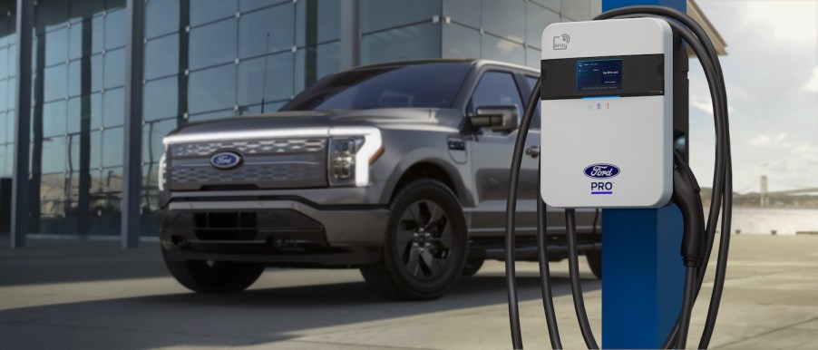 Ford F-150 Lightning parked behind a Ford Pro EV charger.