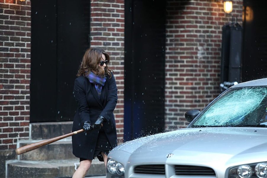 Tina Fey smashes a car windshield in a celebrity car bit.