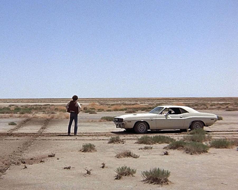 Actor Barry Newman stands in the desert alongside a 1970 Dodge Challenger R/T from the movie 'Vanishing Point'.