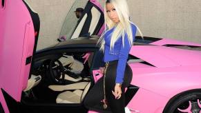 Nicki Minaj poses with her pink Lamborghini Aventador at an event.