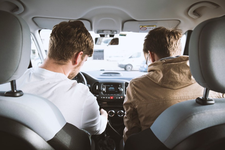 A driver and a passenger sitting in a car during a road trip.