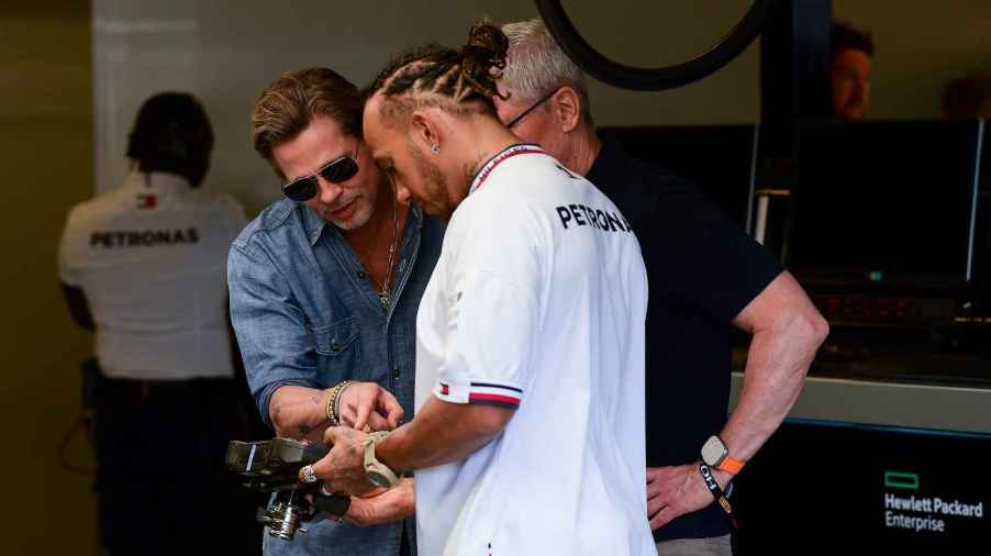 Brad Pitt stands closely to Lewis Hamilton in the garage at F1 Grand Prix of USA at Circuit of The Americas on October 23, 2022 in Austin, Texas