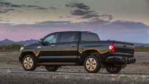 A black 2016 Toyota Tundra parked in left profile view outside at dusk