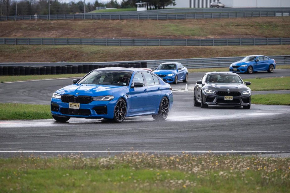 Four BMW sports cars race on a track.