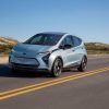 A Chevrolet Bolt EV drives across a desert highway.