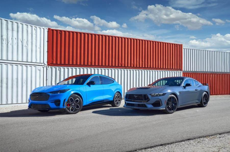 A blue Ford Mustang Mach-E and a GT Coupe park in a harbor.