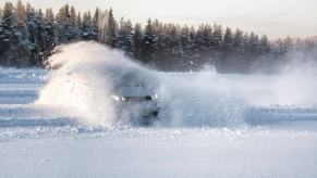 Car doing donuts and skidding across a snow-covered parking lot.